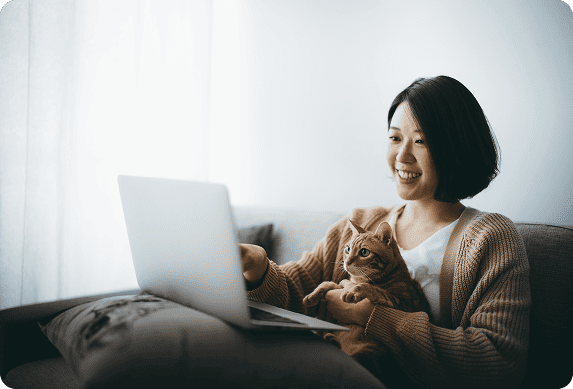 A woman on a laptop with a cat